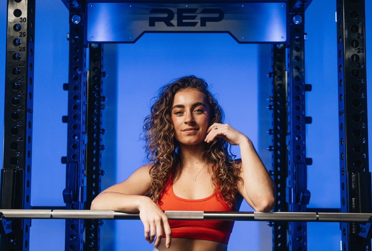 Demi Bagby poses on her REP Fitness PR 5000 power rack.
