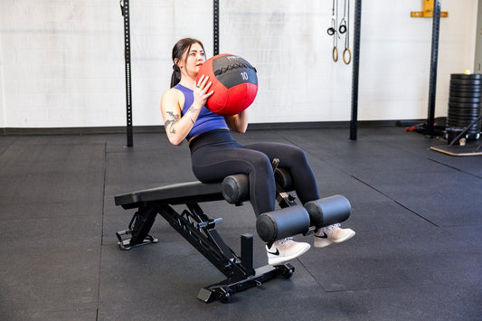 An athlete does core work on a decline bench with the REP® medicine ball.