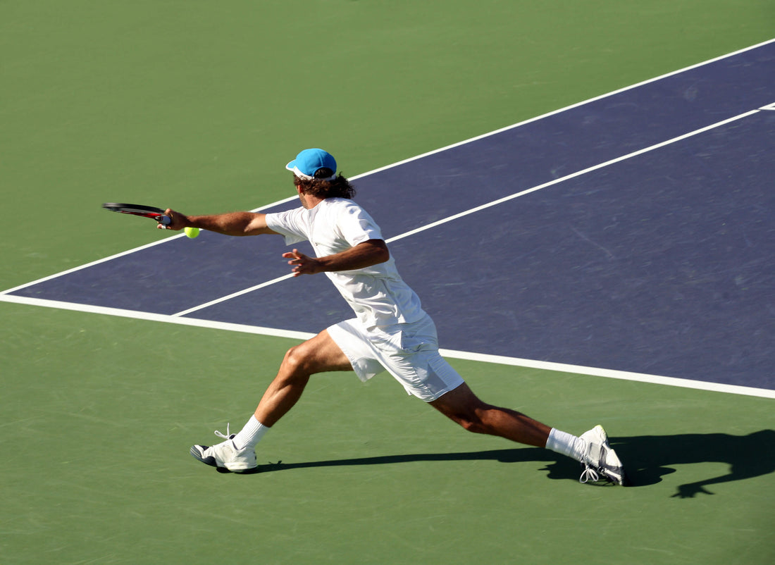 A man reaches for a shot during a tennis match.
