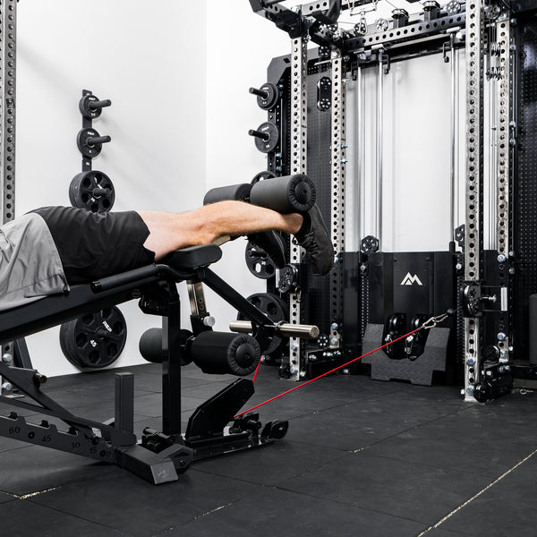 Athlete using the Leg Extension & Leg Curl Bench Attachment Cable Kit with an Ares 2.0