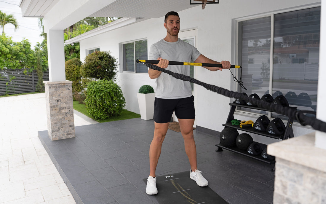 Front shot: Athlete working out outside with the TRX® Rip Trainer™ relaxed in front of them