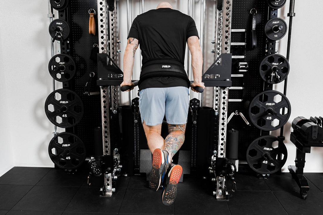 Person using belt squat belt for weighted dips
