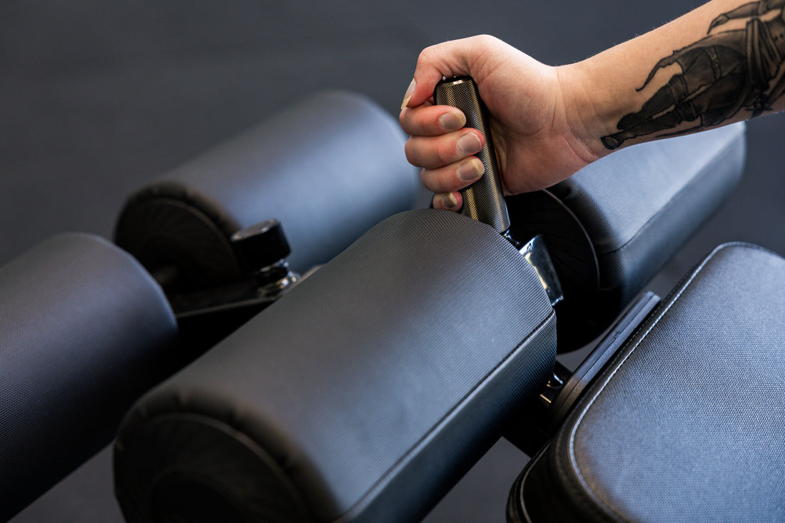 Athlete gripping the knurled handle on the Adjustable Bench Leg Roller Attachment 2.0