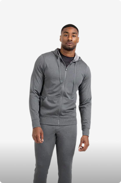 Man wearing a gray zip-up hoodie and pants on a white background