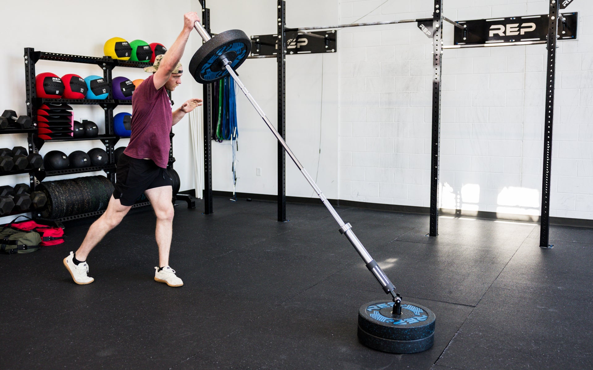 An athlete performing standing presses with the Free Standing REP® x Kleva Built® Adroit Landmine