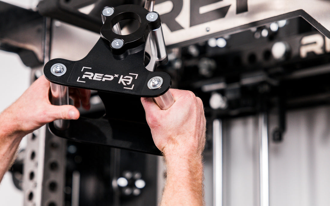 Athlete grabbing the REP® x Kleva Built® Angled Atlas™ Close-Grip Cable and Landmine Attachment from lat pulldown cable