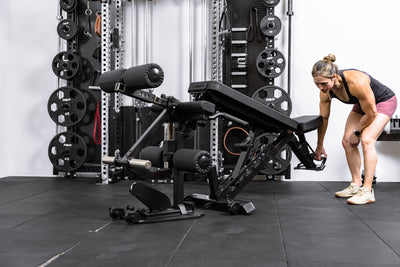 Athlete wheeling a Nighthawk bench up to the Leg Extension & Leg Curl Bench Attachment