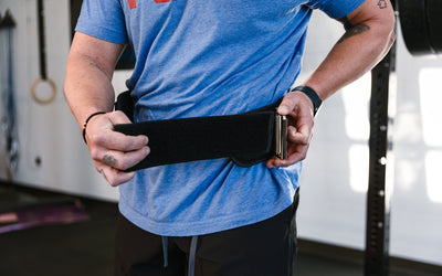 Athlete putting on the REP Nylon Lifting Belt.
