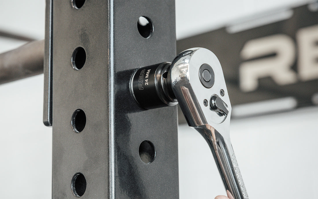 A ratchet wrench with REP's 24mm Rack Socket installing a bolt on a 4000 Series Power Rack