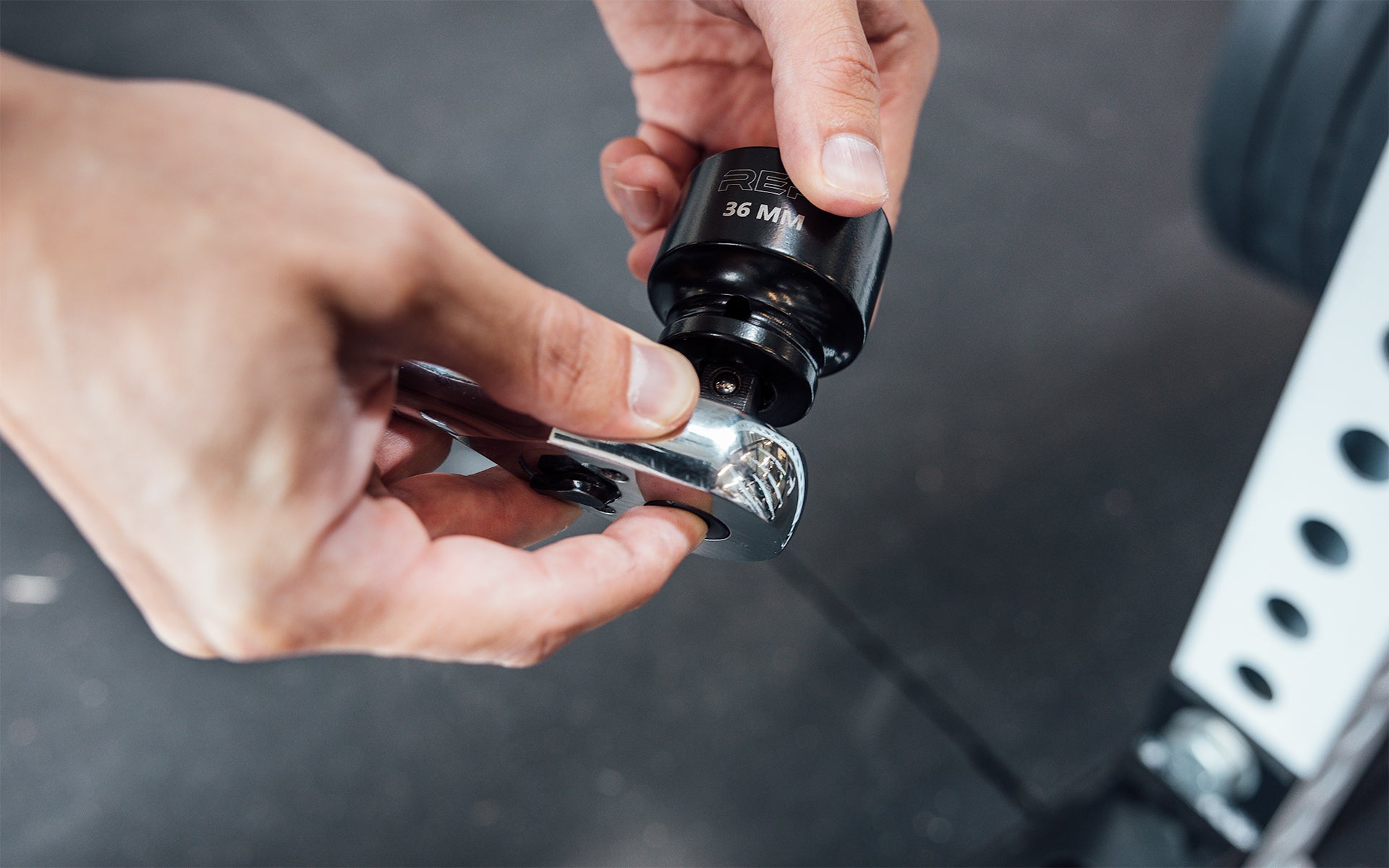 Someone attaching REP's 36mm Rack Socket to a ratchet wrench for installing 5000 Series Power Racks