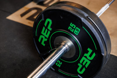 Close-up: A 25 lb REP Sport Bumper Plate 2.0 interlocks seamlessly with a 45 lb plate on the sleeve of a barbell