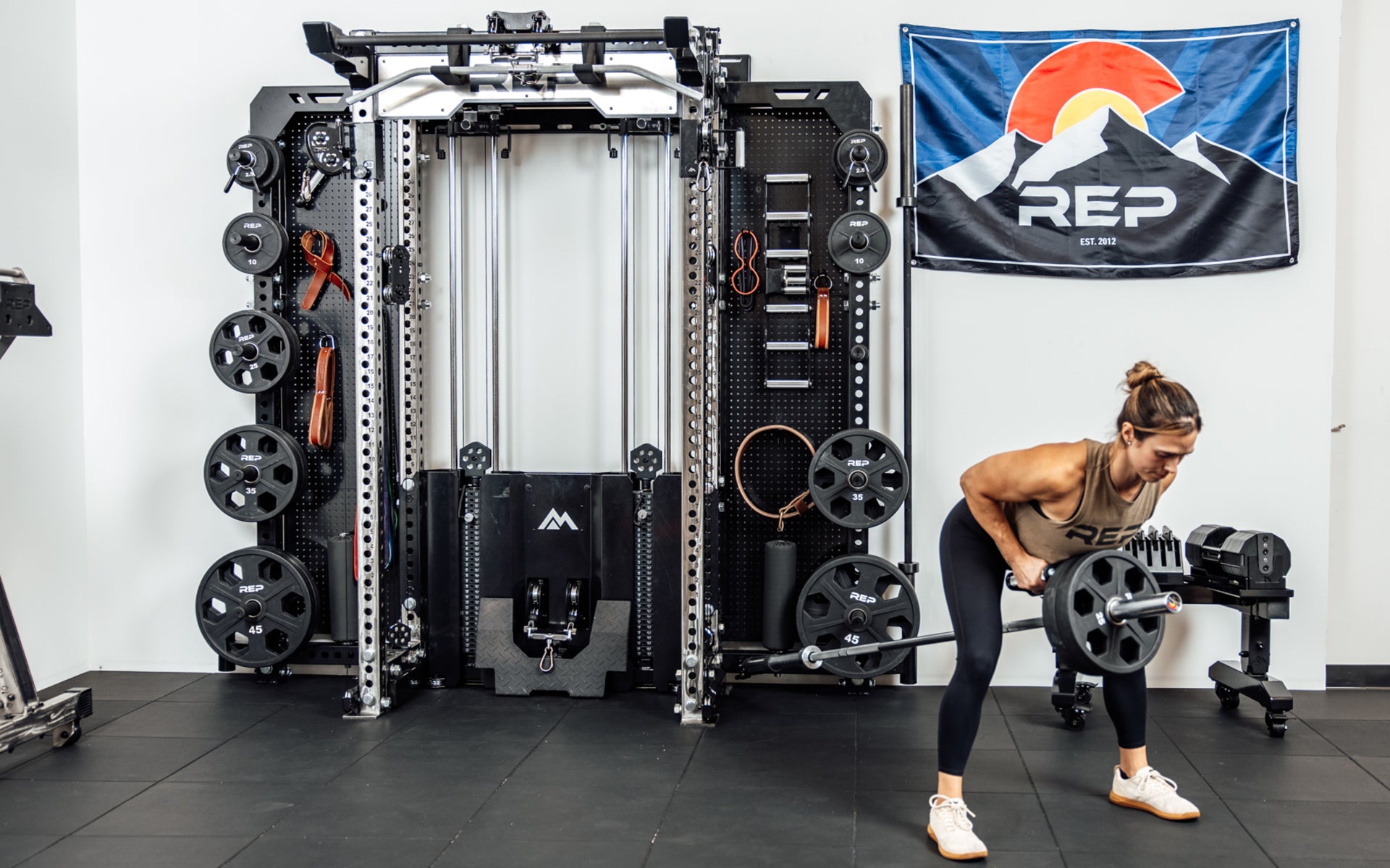 An athlete using the Rack Mounted REP® x Kleva Built® Adroit Landmine to do rows on the Wall-Mounted Ares™ 2.0